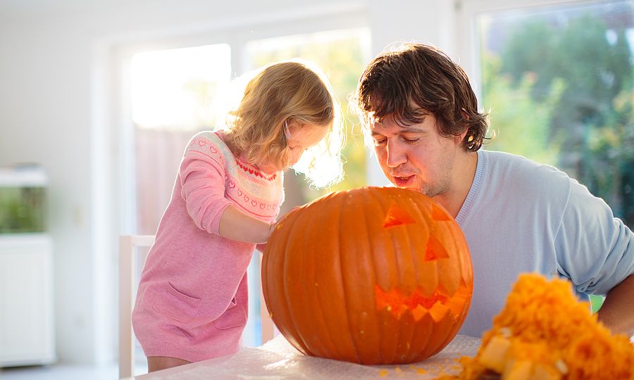 Father And Child Carving Pumpkin For Halloween.