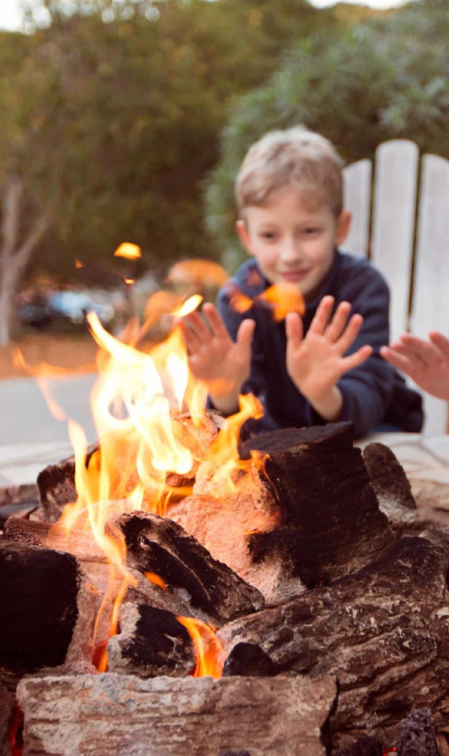 A kid by a campfire