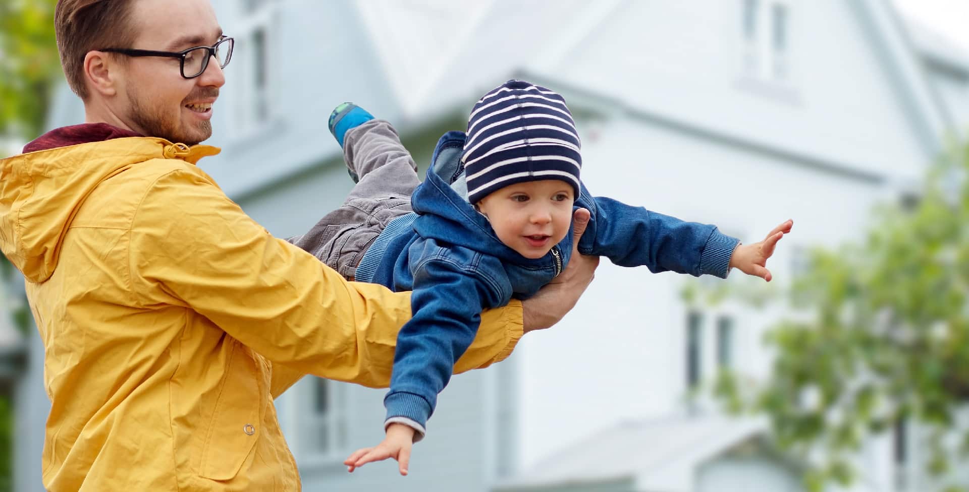 A man in a yellow jacket holding a child