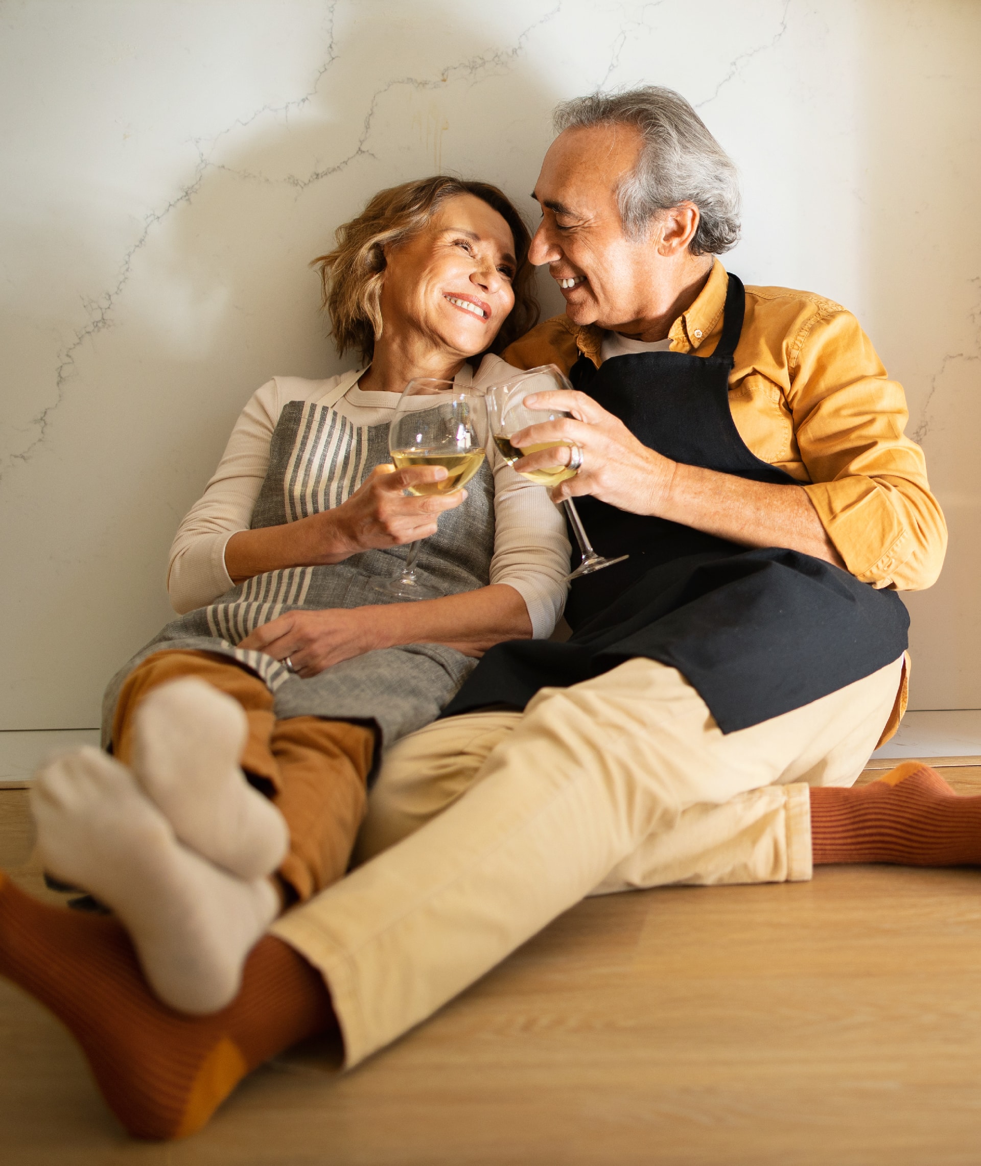 An elderly couple sharing wine on the floor