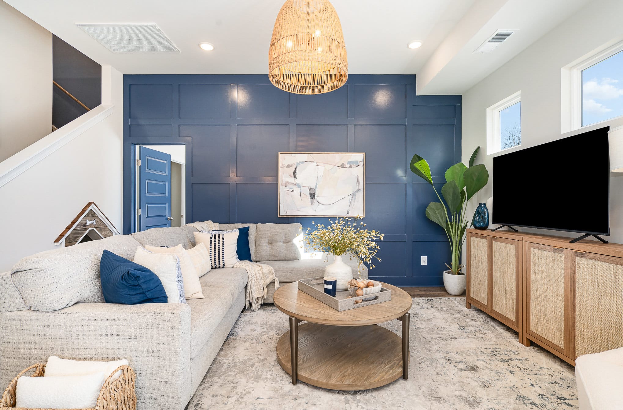 A living area with a blue accent wall in the cambridge series home by patterson company