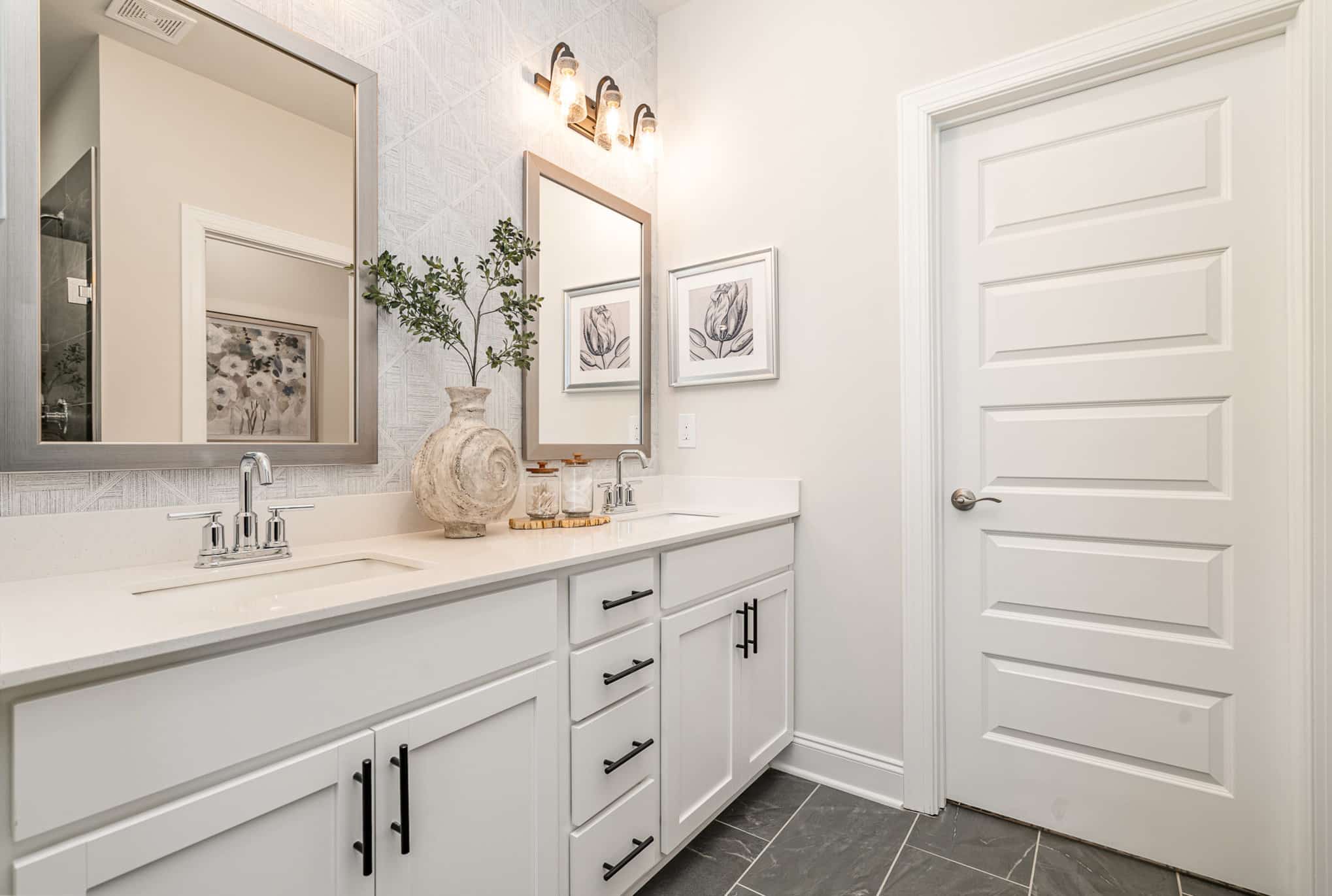 A bathroom with two sinks in the Hanover series model home by Patterson Company